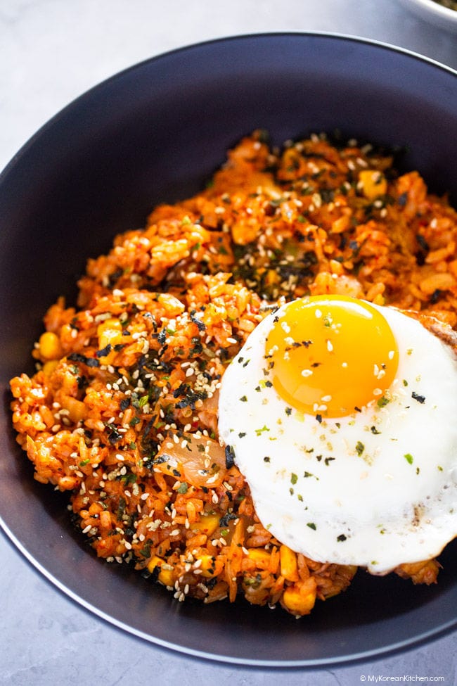 Close up photo of tuna kimchi fried rice served in a black pasta bowl