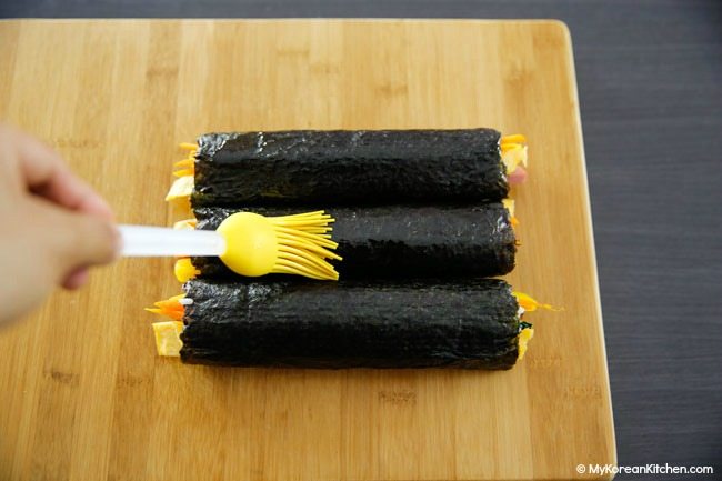 Brushing sesame oil on kimbap
