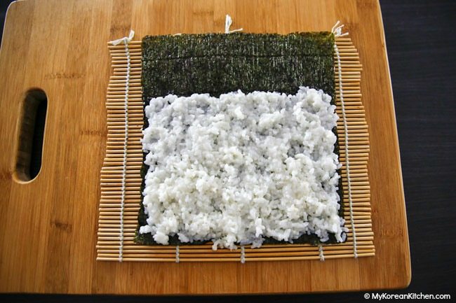 Rice and dried seaweed on bamboo mat