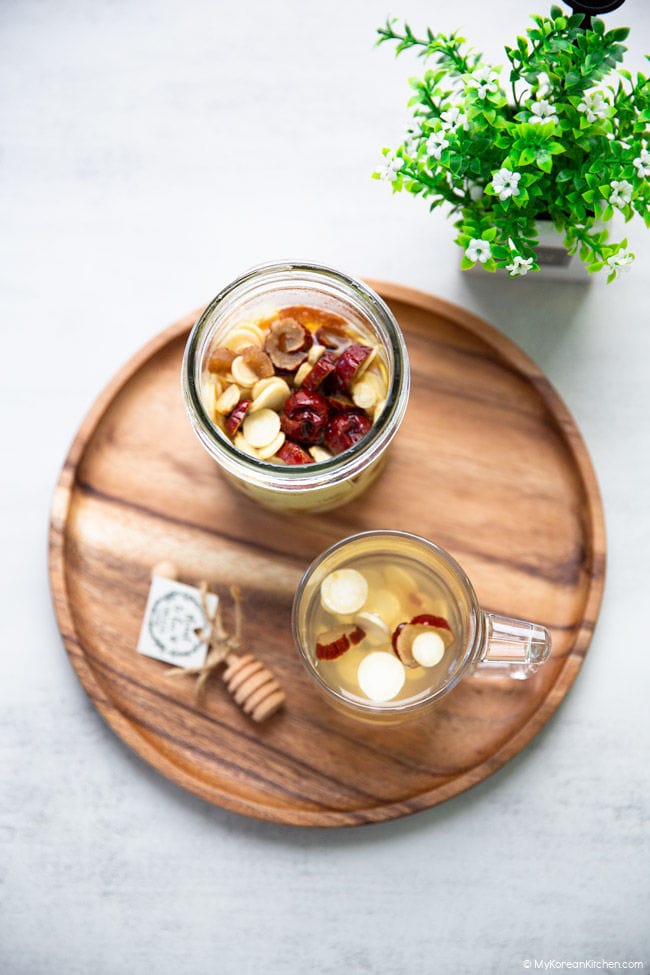 Top-down shot of ginseng tea and ginseng honey marmalade served on a wooden tray.