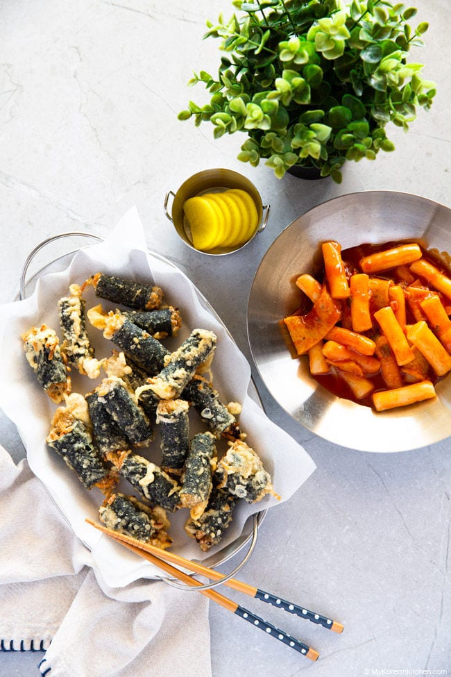 Gimmari is served with tteokbokki (spicy rice cakes) and yellow pickled radish.