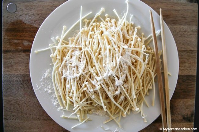 Coating enoki mushrooms with flour