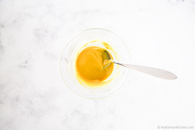 Dipping sauce in a clear bowl, with a spoon.