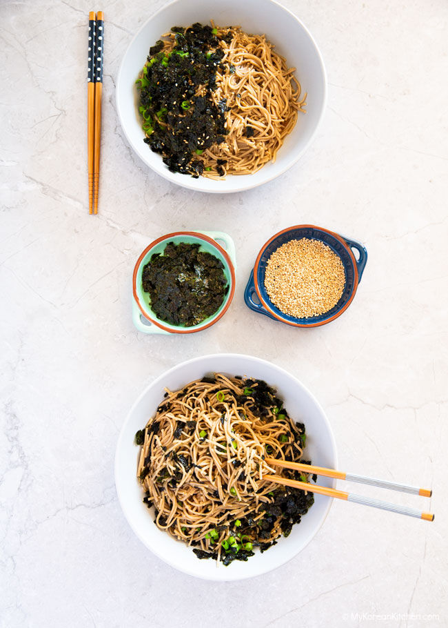 Two bowls of cold soba noodles served on a marble top background.