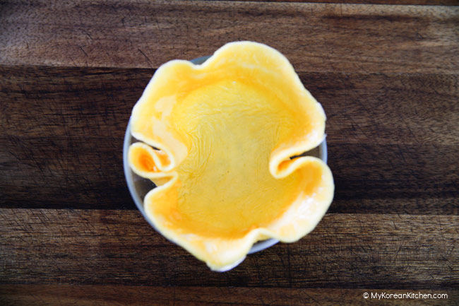 Omelette tucked in a small bowl making a shell