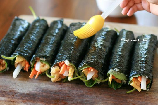Pasting sesame oil on inari roll (yubu kimbap)
