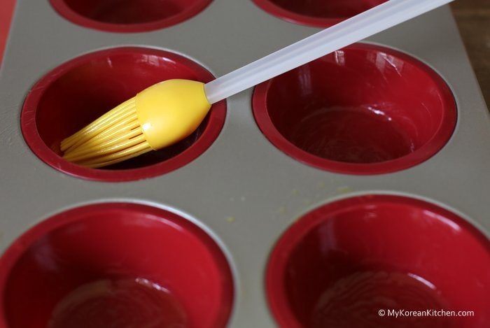 Brush some melted butter on the individual muffin holes of the tray