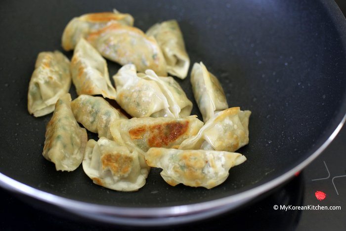 Dumplings sizzling in a pan.