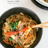 Japchae in a black bowl