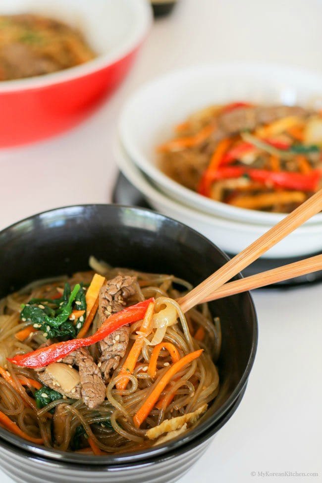 Korean glass noodles served in a black bowl