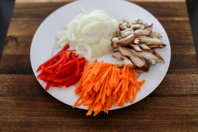 Thinly sliced vegetables on white plate