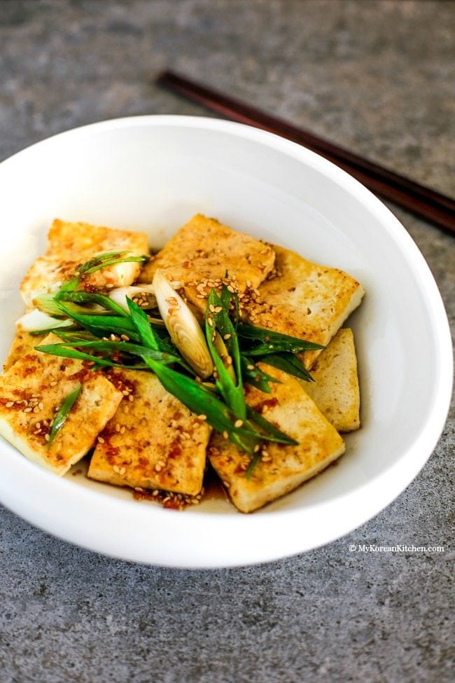 Easy and delicious Korean tofu side dish - Pan Fried Tofu in Garlic Soy Sesame Sauce (Dubu Buchim) recipe. Budget friendly and Vegetarian friendly | MyKoreanKitchen.com