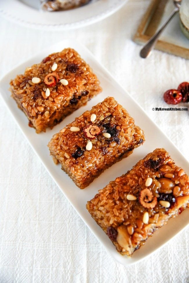 Close up photo of Yaksik dessert elegantly served on a rectangular white plate.