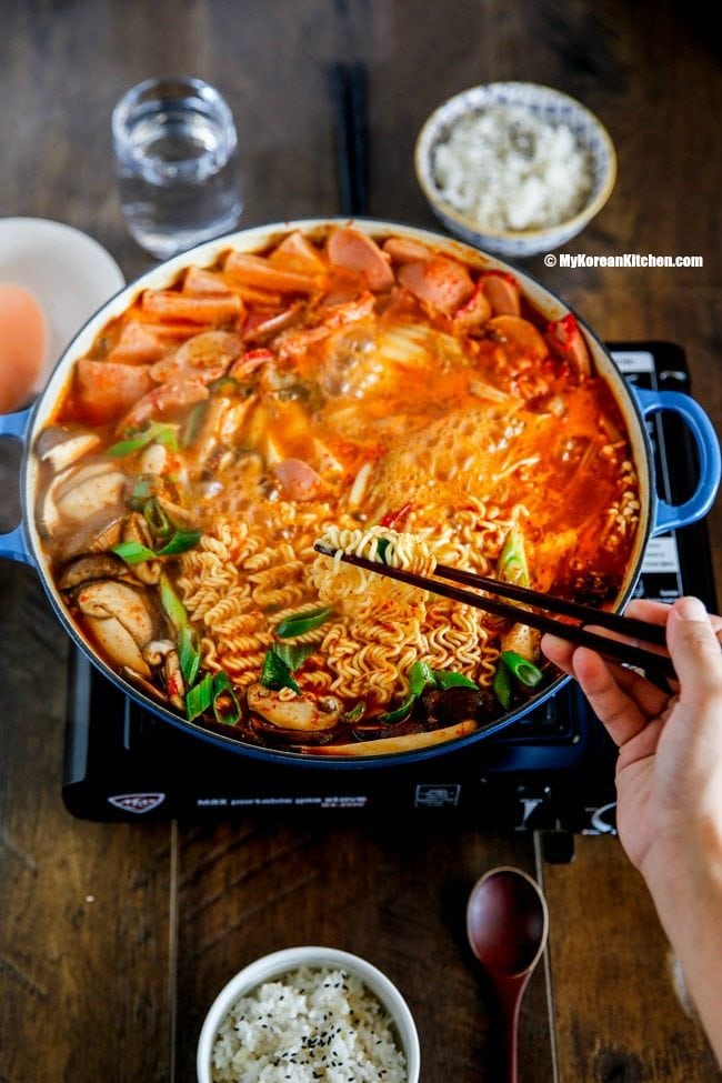 Korean army stew (Budae Jjigae) is a Korean fusion hot pot dish loaded with Kimchi, spam, sausages, mushrooms, instant ramen noodles and cheese. The soup is so comforting and addictive! | MyKoreanKitchen.com