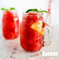 Two glass jugs of Korean watermelon punch, filled with watermelon and ice.