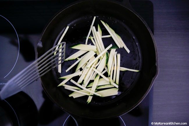 Stir frying julienned zucchinis