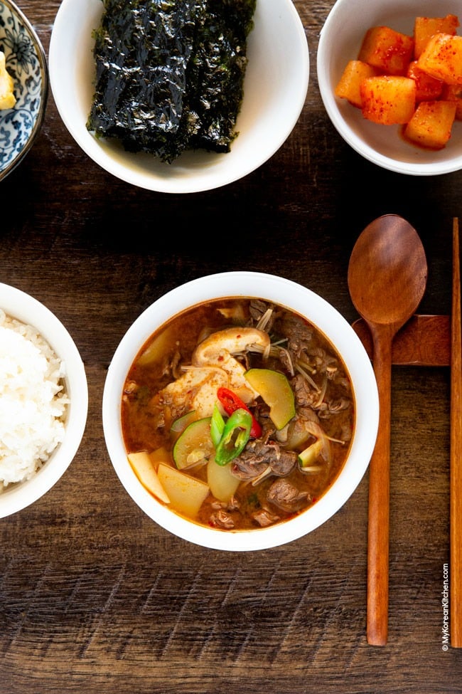 Korean soybean paste stew served with Korean egg rolls, seasoned seaweed and radish kimchi