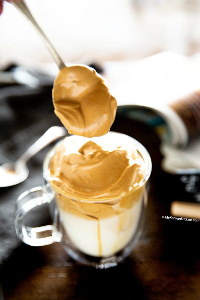 Dolloping whipped coffee over milk