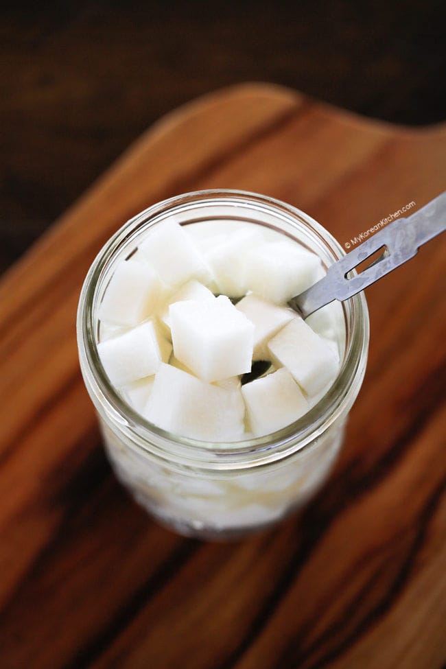 Pickled radishes in a jar with a spoon