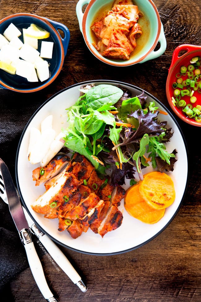 gochujang chicken served with salad, kimchi, pickled radish