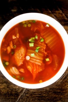 Kimchi soup served in a white soup bowl