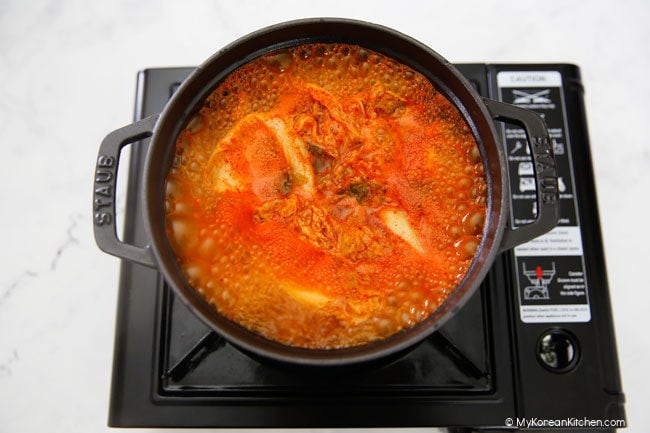 Kimchi soup boiling in black pot