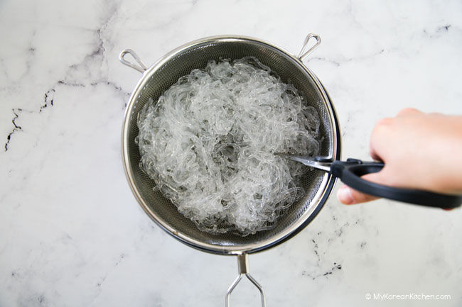 Cutting kelp noodles with a pair of scissors