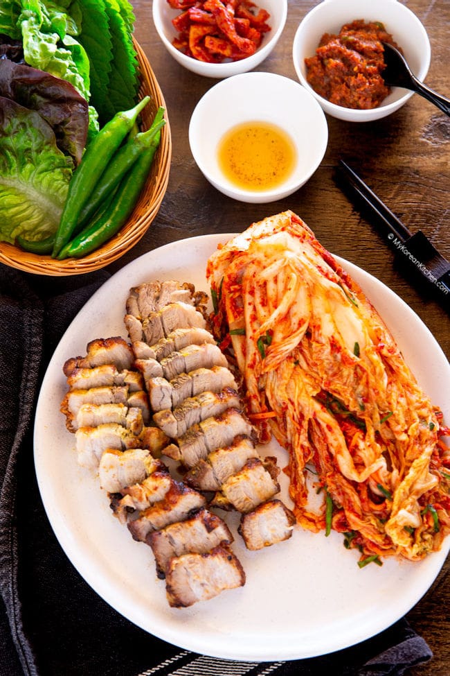 Air fried pork belly bites served with kimchi, lettuce and other Korean condiments