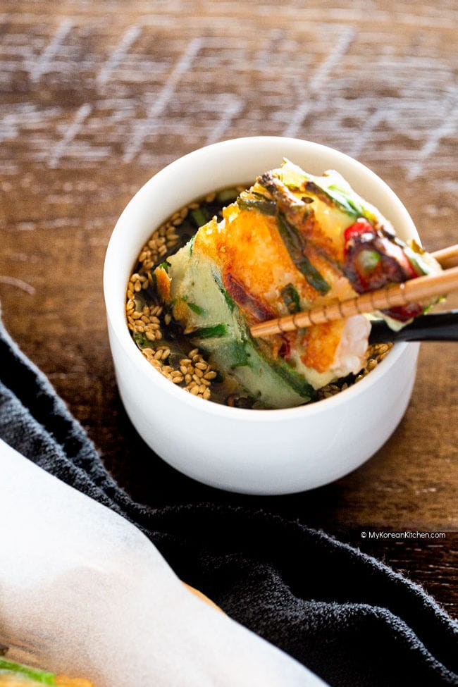 Dipping chive pancake in sauce