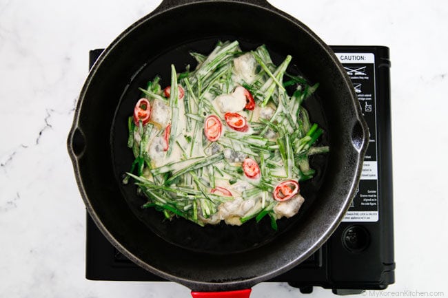 Chive pancake batter on a cast iron skillet