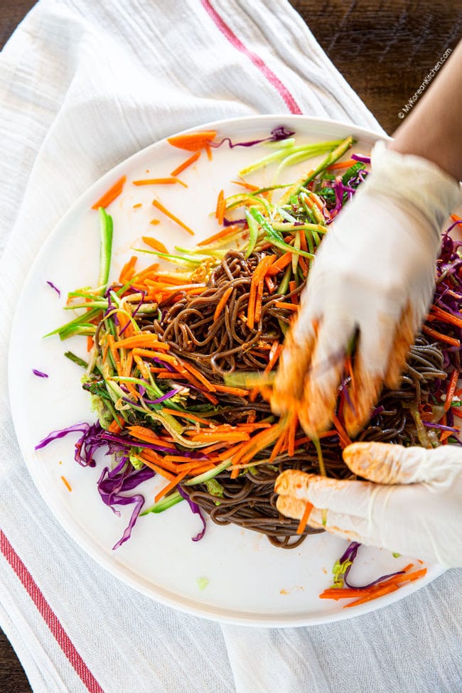 Mixing soba noodles with vegetables and sauce