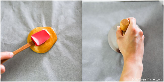 tapping dalgona with a spatula to test dryness and pressing down with hotteok press