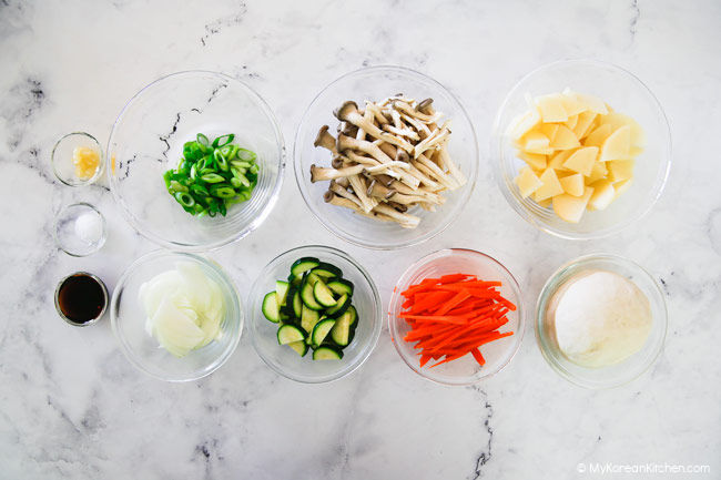 Sujebi ingredients lined up on a white marble bench top