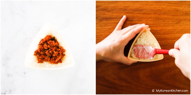 Filling cooked pork kimchi and rice in a triangle kimbap mold.