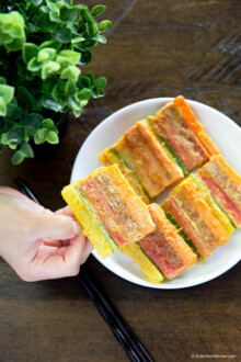 Holding cooked sanjeok (meat and vegetable skewers).