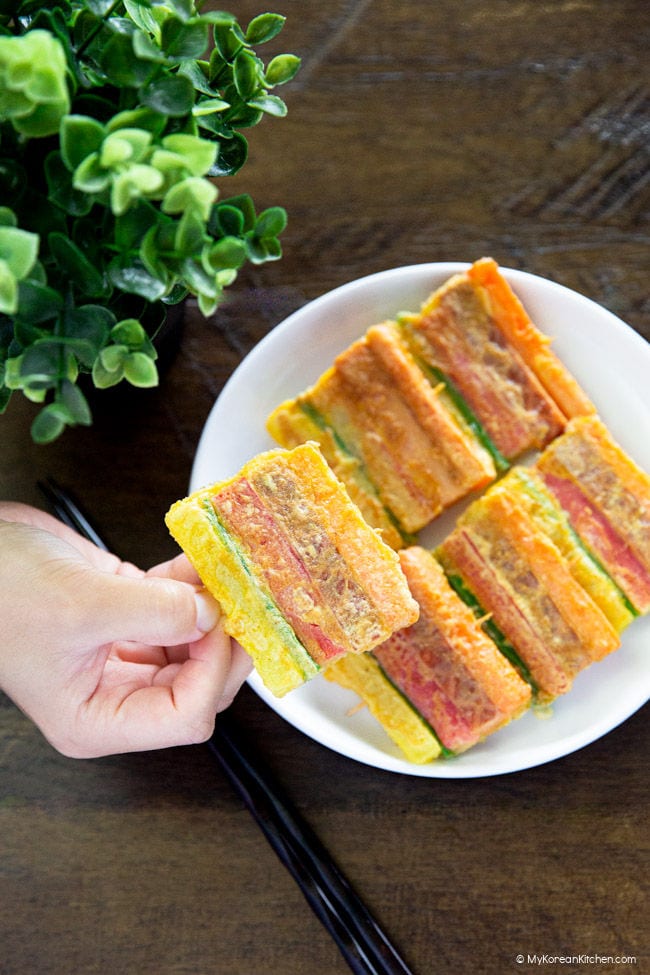 Holding cooked sanjeok (meat and vegetable skewers).