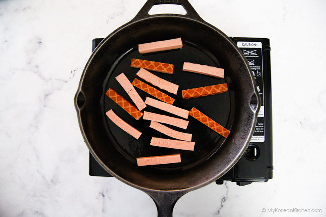 Cooking the ham slices in a frying pan.