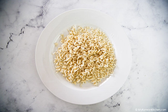 Crushed ramen noodles on a white plate.
