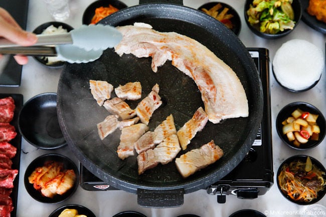 Grilling pork belly (samgyeopsal) in a Korean BBQ grill pan.