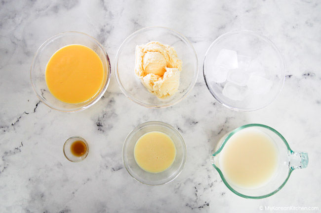 Ingredients for makgeolli shake lineup on a white marble background.