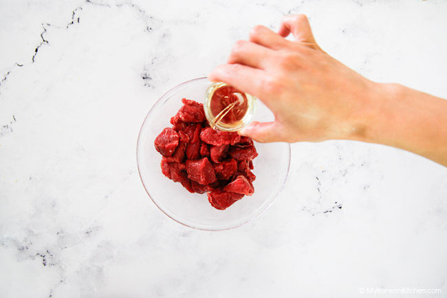 Adding mirin over diced beef.
