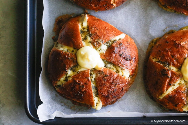 Close-up photo of cream cheese garlic bread on a baking tray.