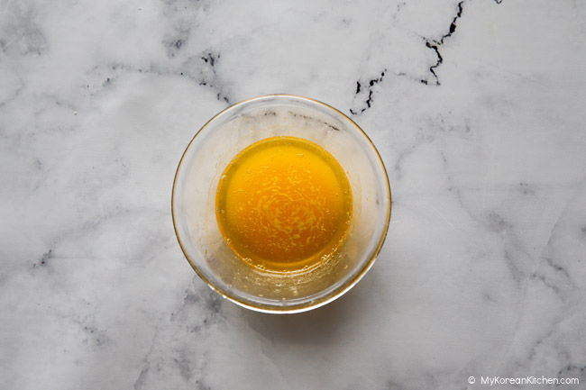 Melted butter in a small clear glass bowl.