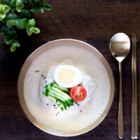 Kongguksu served in brassware on a wooden backdrop