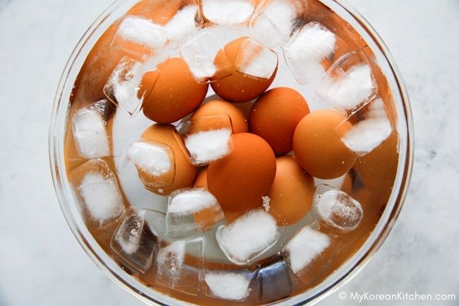 Boiled eggs soaking in a bowl of ice and water to cool down.